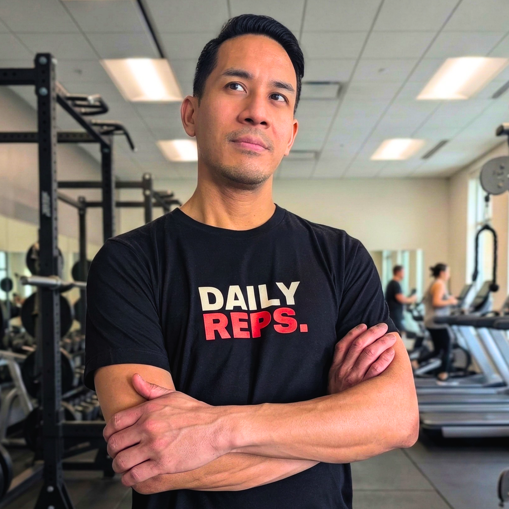 Man wearing a black t-shirt with 'DAILY REPS.' in a gym setting