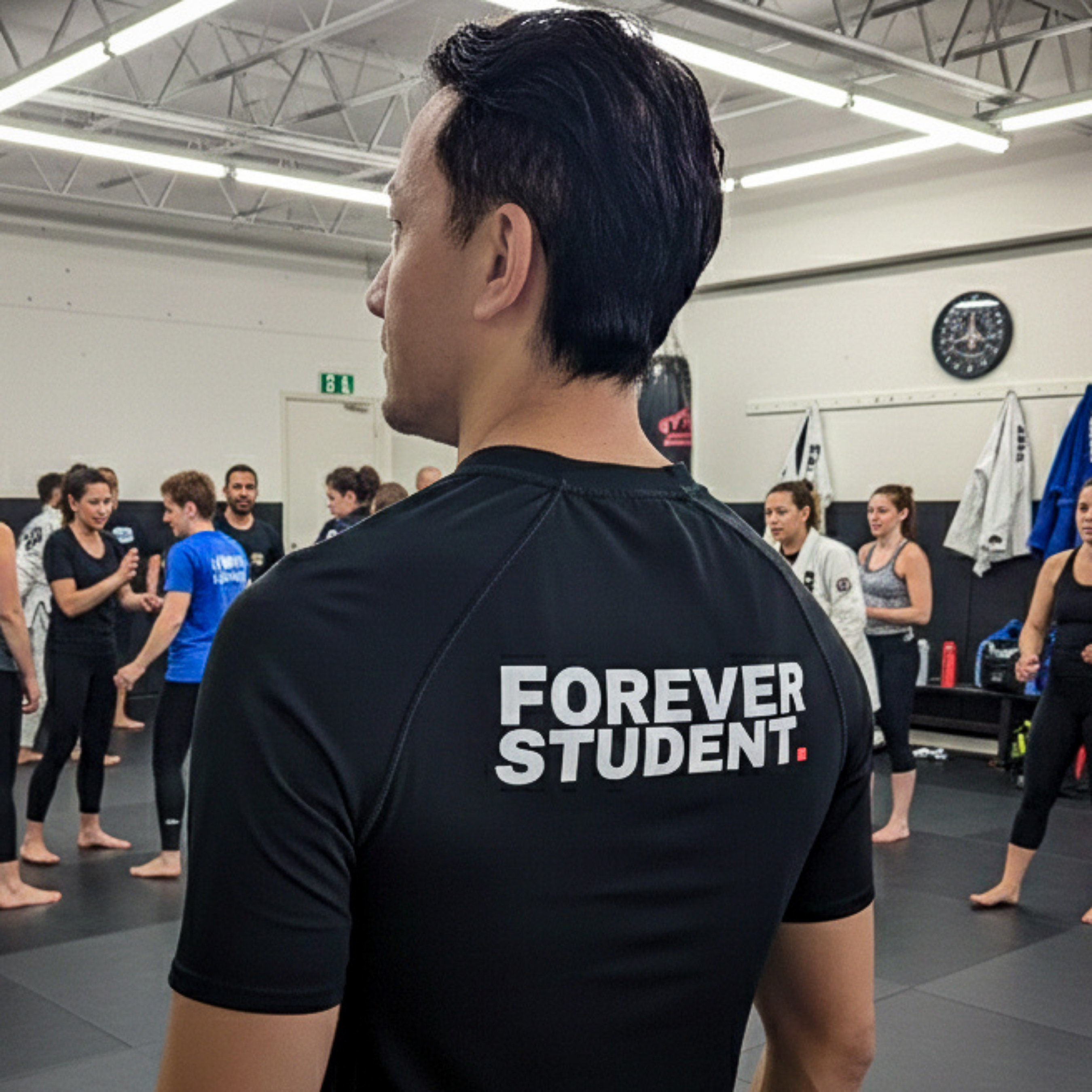Person wearing a black t-shirt with 'Forever Student' text in a gym setting.