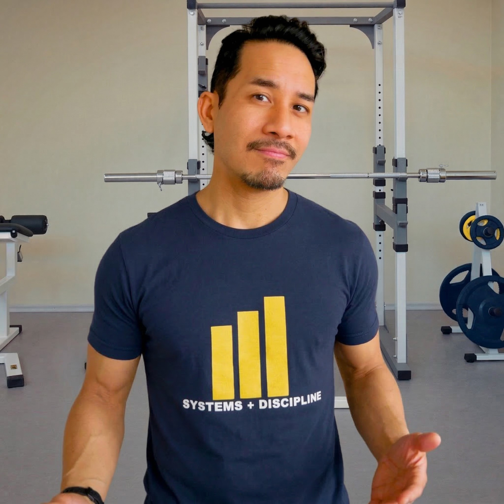 Man wearing a navy blue t-shirt with yellow graphics and text in a gym setting